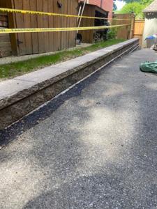 Driveway retaining wall with grading for slope stabilization.